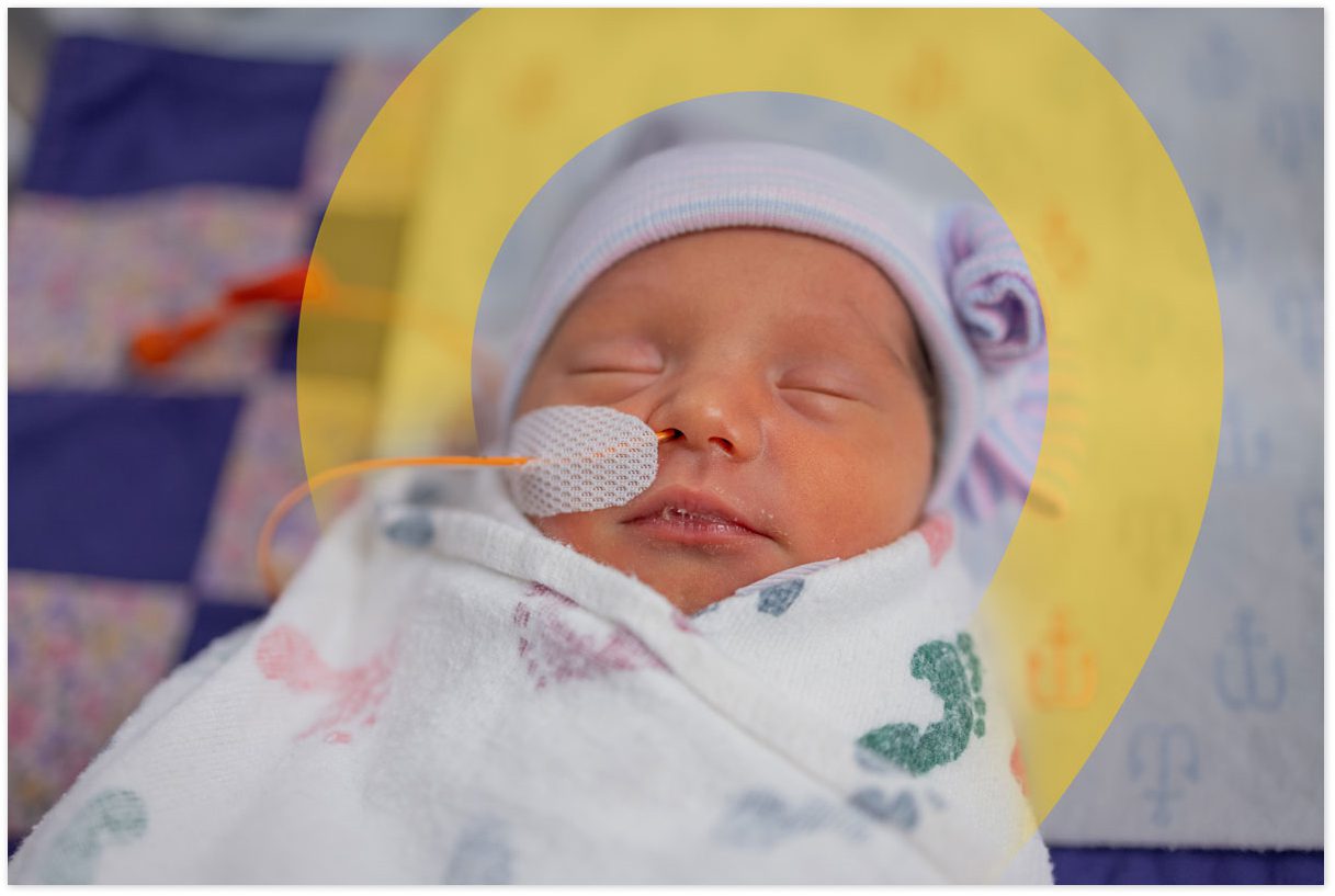 Newborn baby wrapped in a hospital blanket.